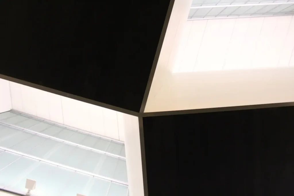 Sala de estar moderna com molduras de gesso brancas no teto e nas paredes, com foco nos detalhes do acabamento e iluminação indireta.